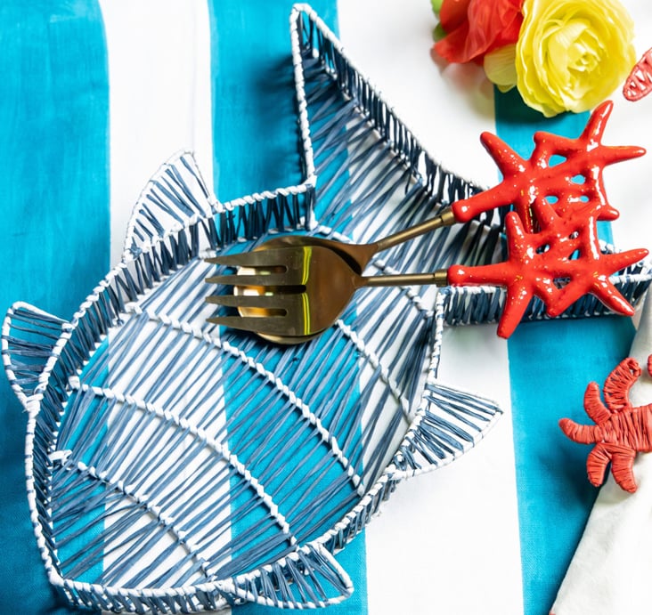 Les-Ottomans blue ceramic fish-shaped dish and coral-red decorative objects on a turquoise surface