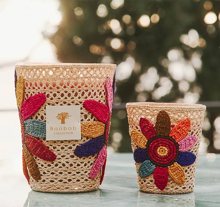 Two Baobab Collection 'Girasol' woven candles decorated with embroidered flowers