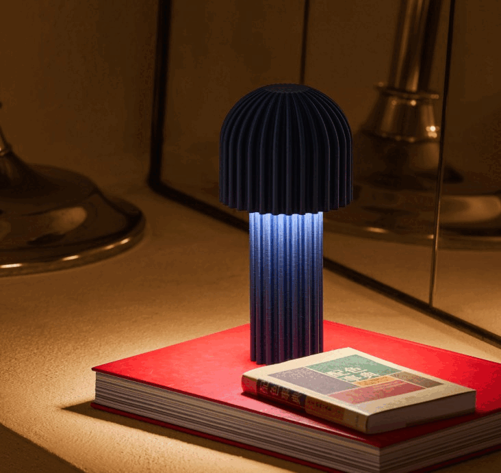 An Artetica floor lamp with a ribbed cylindrical shade glowing in a warm domestic interior