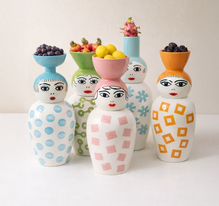 Five Seletti 'Canopie' ceramic jars with hand-painted faces and colourful patterns displayed on a white surface